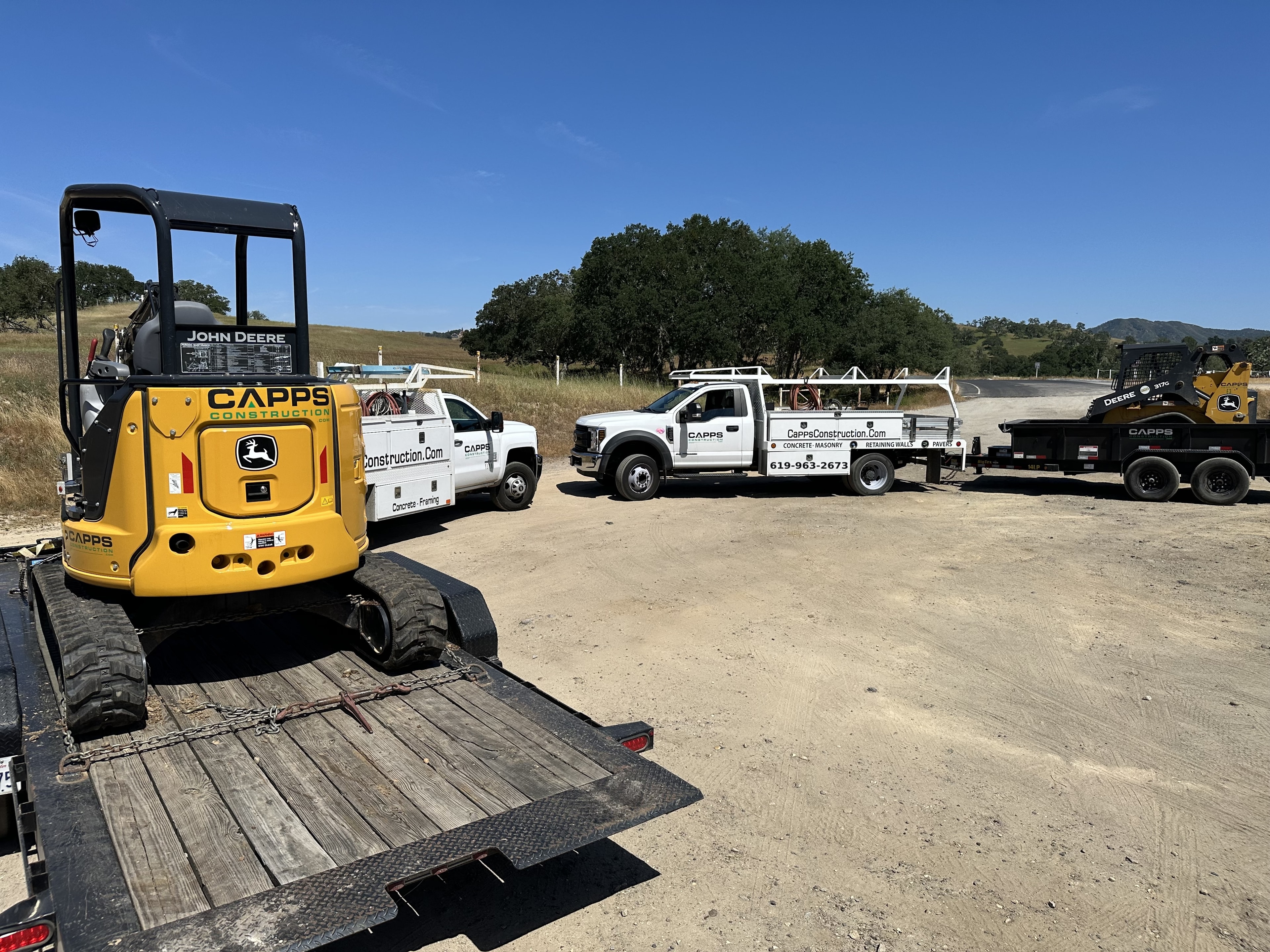 Capps Construction fleet — trucks and John Deere equipment at job site