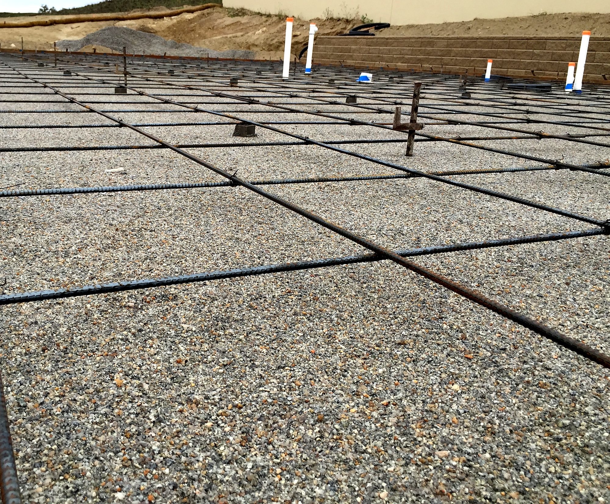 Rebar grid over gravel base before a slab pour by Capps Construction