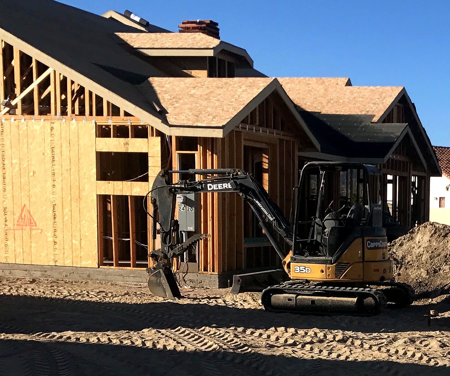 Mini excavator doing site work at a new home by Capps Construction