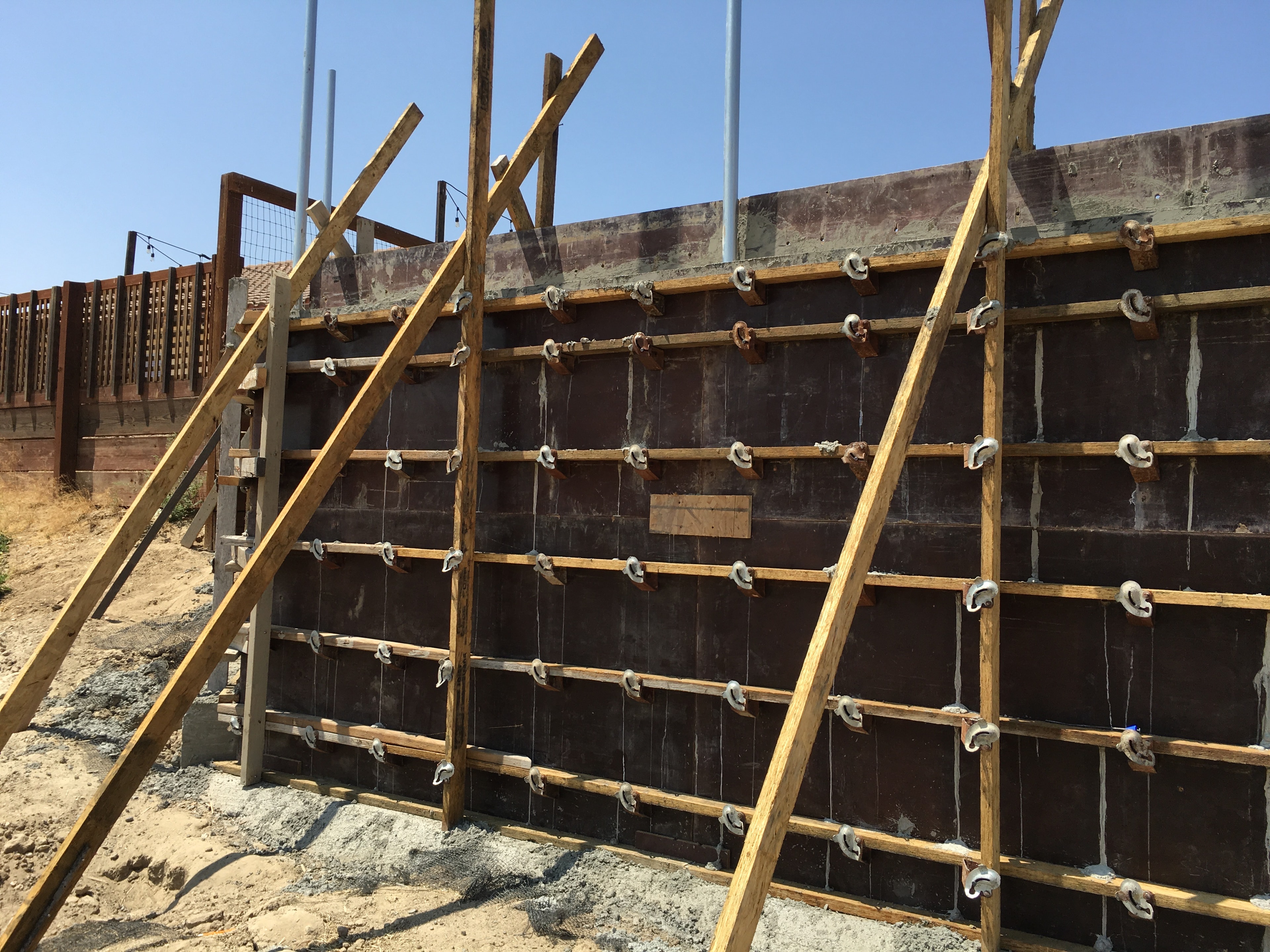 Braced wood formwork for a poured-in-place concrete retaining wall